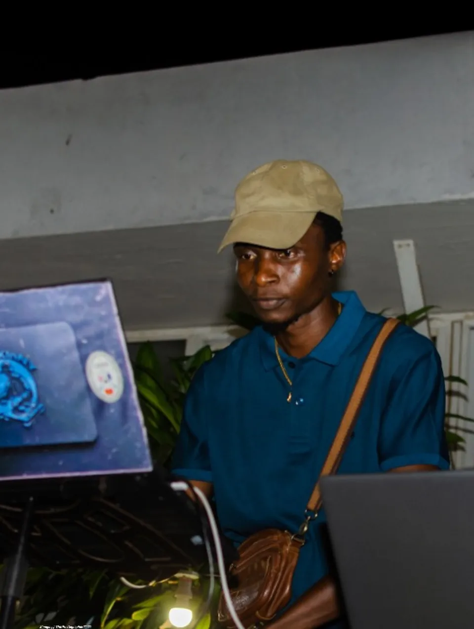 A DJ in a tan cap behind a laptop at The Hangawt