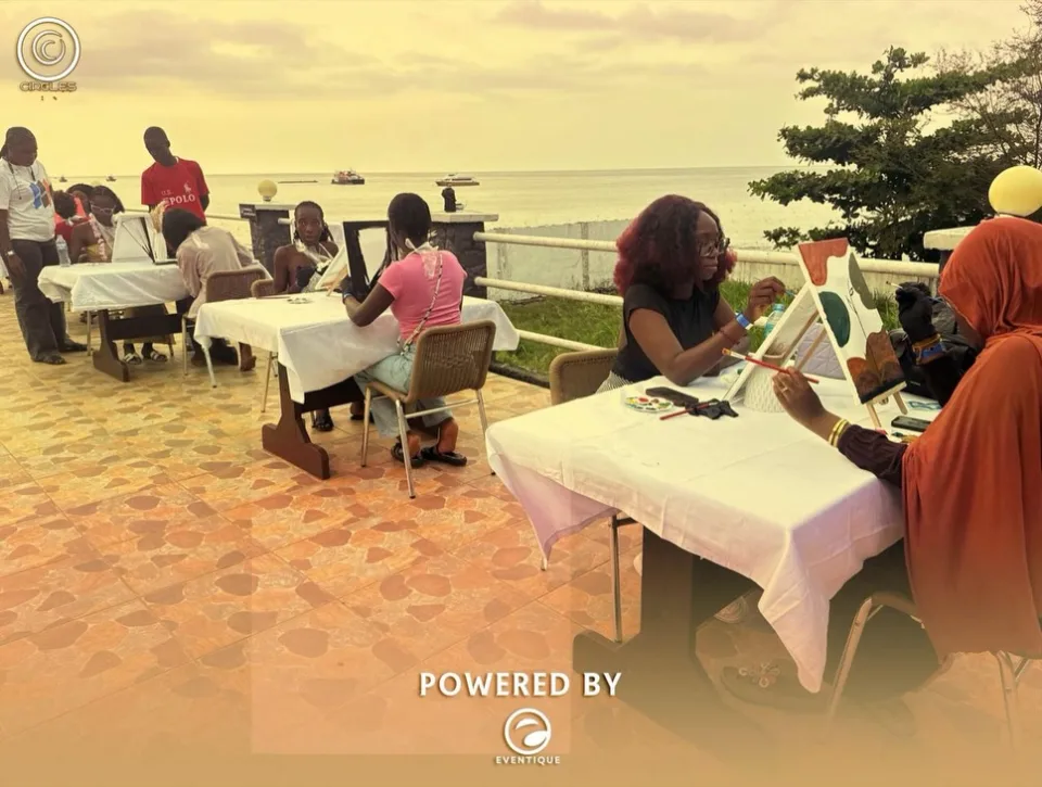 Guests painting at outdoor tables beside the sea at a previous Hangawt