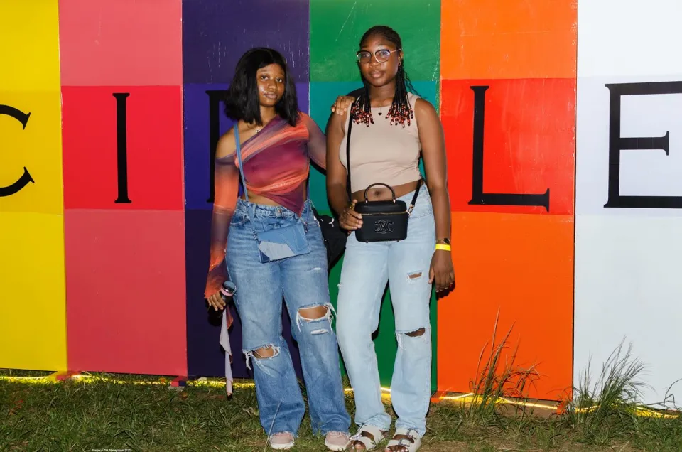 Two friends posing in front of the colourful Circles backdrop