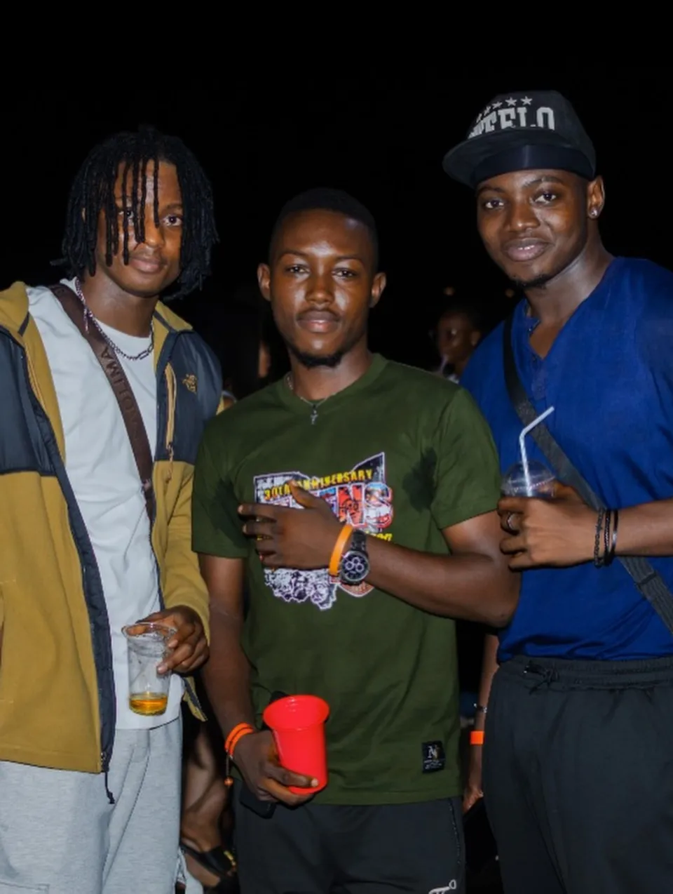Three friends posing at an evening gathering