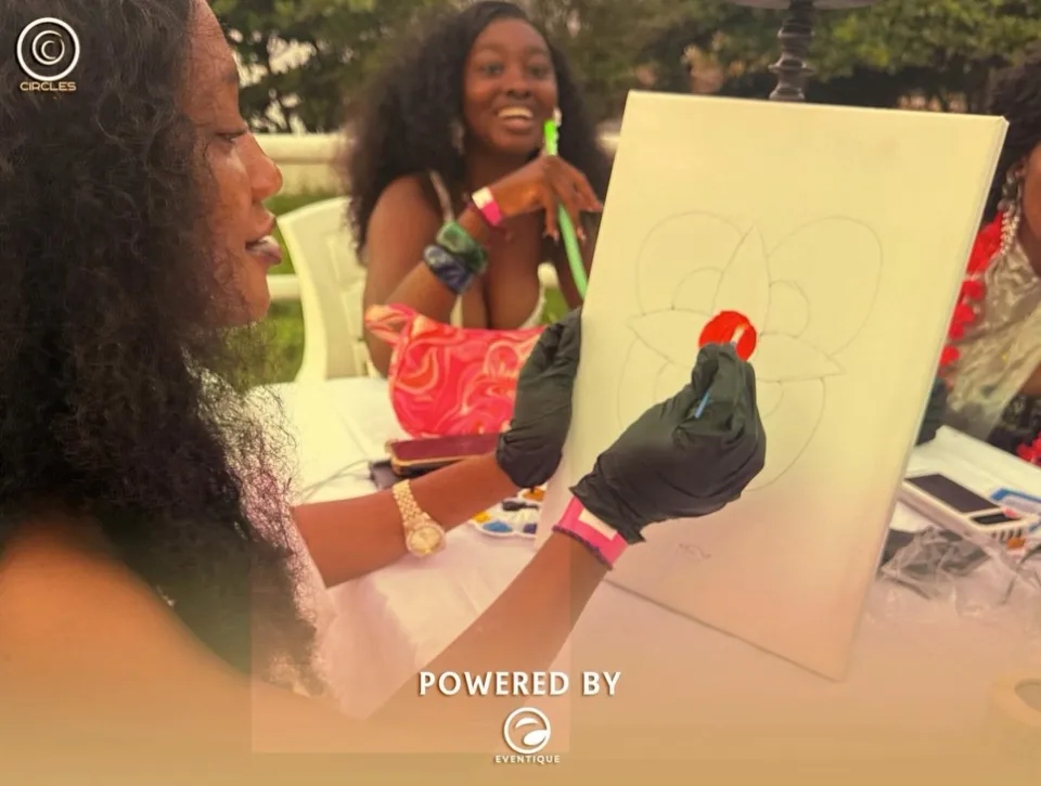 Guests painting small canvases at an outdoor table